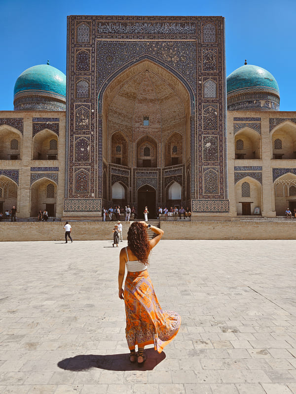 ragazza con capo coperto vicino ad una madrasa in uzbekistan